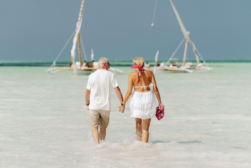Retraite carrière longue : couple de jeunes retraités au bord de la mer